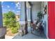 Welcoming porch with two rocking chairs, accent pillows, stone pillars, and a red door at 414 Finn Way # 4, Dunedin, FL 34698