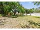 Expansive backyard with mature trees, a picnic table, fire pit and perimeter fence at 4161 Rolling Springs Dr, Tampa, FL 33624