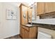 Bathroom featuring wood cabinets, granite counters and mosaic tile detail at 4161 Rolling Springs Dr, Tampa, FL 33624
