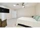 Spacious bedroom features a ceiling fan, tv, chair, and an open doorway to another room at 4161 Rolling Springs Dr, Tampa, FL 33624
