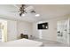 Spacious bedroom features a ceiling fan, tv, chair, and an open doorway to another room at 4161 Rolling Springs Dr, Tampa, FL 33624