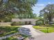 Charming single-story home with a well-manicured front yard, circular driveway, and mature trees at 4161 Rolling Springs Dr, Tampa, FL 33624