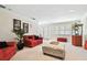 Bright living room features neutral carpet, red sofas, plantation shutters, and a popcorn machine at 4161 Rolling Springs Dr, Tampa, FL 33624