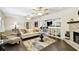 Spacious living room with a fireplace, hardwood floors, neutral furniture, and view into the dining room at 4161 Rolling Springs Dr, Tampa, FL 33624