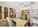 Home office featuring custom built-ins, a large desk, neutral colors, and a view into the living room at 4161 Rolling Springs Dr, Tampa, FL 33624
