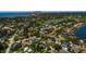 Aerial view showcases the neighborhood with mature trees, a golf course, and a distant city skyline at 459 Bayview Ne Dr, St Petersburg, FL 33704