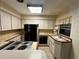 Bright kitchen with white cabinets, tile countertops, and a full suite of appliances, including a cooktop at 459 Bayview Ne Dr, St Petersburg, FL 33704