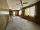 Wood paneled living room with multiple ceiling fans and retro curtains at 459 Bayview Ne Dr, St Petersburg, FL 33704