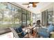 The screened lanai offers a tranquil space for relaxation and outdoor dining with a ceiling fan and comfortable seating at 4656 Copper Hill Dr, Spring Hill, FL 34609