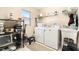 Efficient laundry room featuring a utility sink, washer, dryer, and storage shelves at 4656 Copper Hill Dr, Spring Hill, FL 34609