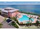 Aerial view of a community pool and hot tub, with tropical landscaping and ocean view at 4799 Coquina Key Se Dr, St Petersburg, FL 33705