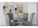 Cozy dining area with a round glass table set beneath modern art at 4900 Brittany S Dr # 1414, St Petersburg, FL 33715