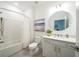 Bright bathroom with a modern vanity, round mirror, and shower-tub combination at 5597 Bay Tide Ct, Land O Lakes, FL 34638