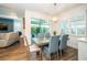 Bright dining area with wood-look floors, a modern light fixture and sliding door access to the lanai at 5597 Bay Tide Ct, Land O Lakes, FL 34638