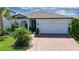 Charming single-Gathering home featuring lush landscaping, a paver driveway, and a welcoming covered porch at 5597 Bay Tide Ct, Land O Lakes, FL 34638