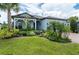 Charming home featuring lush landscaping, a well-manicured lawn, and a welcoming covered entryway at 5597 Bay Tide Ct, Land O Lakes, FL 34638