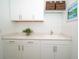 Well-lit laundry room with white cabinets, granite countertops, and a sink at 5597 Bay Tide Ct, Land O Lakes, FL 34638