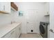 Efficient laundry room with white cabinets, sink, and modern washer at 5597 Bay Tide Ct, Land O Lakes, FL 34638