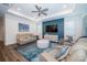 Modern living room with tray ceilings, blue accent wall, stylish furniture, and luxury vinyl floors at 5597 Bay Tide Ct, Land O Lakes, FL 34638