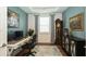 Home office offers a desk, rolling chair, a large grandfather clock, and great lighting at 5597 Bay Tide Ct, Land O Lakes, FL 34638