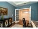 Stylish home office with blue walls, French doors, and modern furnishings; ready to work! at 5597 Bay Tide Ct, Land O Lakes, FL 34638