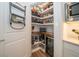 Walk-in pantry featuring built-in shelving, wine fridge, and counter space for organized storage at 5597 Bay Tide Ct, Land O Lakes, FL 34638