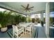 Relaxing screened-in patio with a dining table, ceiling fan, and lush tropical plants for enjoying the outdoors at 5597 Bay Tide Ct, Land O Lakes, FL 34638