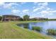 The backyard of a two-story home with screened lanai, grassy yard, and waterfront view at 5656 Cloverleaf Run, Bradenton, FL 34211