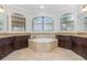 Bathroom suite with a central soaking tub, dual sink vanities, and three large windows at 5656 Cloverleaf Run, Bradenton, FL 34211