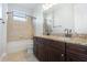 Dual sink bathroom features a granite countertop, dark wood cabinets, and tub shower at 5656 Cloverleaf Run, Bradenton, FL 34211
