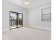 Spacious bedroom with neutral carpet, ceiling fan and glass sliding doors to screened in patio at 5656 Cloverleaf Run, Bradenton, FL 34211