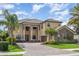 Stately two-story home with lush landscaping, brick driveway, and grand entrance with impressive columns at 5656 Cloverleaf Run, Bradenton, FL 34211