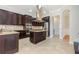 Modern kitchen with dark wood cabinets, stainless appliances, granite countertops and center island at 5656 Cloverleaf Run, Bradenton, FL 34211