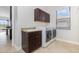 Convenient laundry room with granite countertop, dark wood cabinets and stainless steel washer/dryer at 5656 Cloverleaf Run, Bradenton, FL 34211