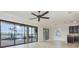 Spacious living room with expansive glass doors, ceiling fan and backyard views provides seamless indoor/outdoor living at 5656 Cloverleaf Run, Bradenton, FL 34211