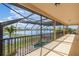 Large screened patio offers lake views with adjacent pool and manicured landscaping at 5656 Cloverleaf Run, Bradenton, FL 34211