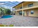 A spacious screened patio on a two-story home with brick flooring and a view of the pool at 5656 Cloverleaf Run, Bradenton, FL 34211