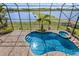Aerial view of screened pool with hot tub overlooking the lake and manicured landscaping at 5656 Cloverleaf Run, Bradenton, FL 34211