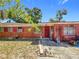 The front of the home is brick with red accents, a welcoming front door, and a well-kept lawn at 5905 Myer St, Tampa, FL 33634