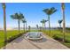 Lush backyard with a tranquil reflecting pool leading to breathtaking water views, framed by swaying palm trees at 6106 Marbella Blvd, Apollo Beach, FL 33572