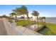 Stunning backyard view featuring a sleek pool, lush lawn, and swaying palm trees overlooking the serene ocean at 6106 Marbella Blvd, Apollo Beach, FL 33572