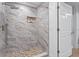 Modern bathroom features a tiled shower with a rainfall showerhead and stone tile floor at 6106 Marbella Blvd, Apollo Beach, FL 33572