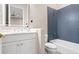 Modern bathroom featuring a white vanity with a bright mirror and a blue tiled shower at 6106 Marbella Blvd, Apollo Beach, FL 33572