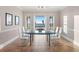 Elegant dining room with glass table and chairs, offering stunning waterfront views and natural light at 6106 Marbella Blvd, Apollo Beach, FL 33572