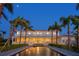 Grand two-story home with a serene water feature and a professionally landscaped yard at twilight at 6106 Marbella Blvd, Apollo Beach, FL 33572