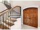 Grand foyer features a curved staircase with wood treads, iron spindles, and a large wooden entry door at 6106 Marbella Blvd, Apollo Beach, FL 33572