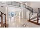 Open-concept foyer featuring a grand staircase and views of a dining area with an ocean backdrop at 6106 Marbella Blvd, Apollo Beach, FL 33572