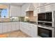Charming kitchen featuring custom white cabinets, stainless steel appliances, and backsplash for a modern touch at 6106 Marbella Blvd, Apollo Beach, FL 33572