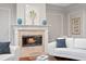 Cozy living room featuring a fireplace, white sofas, and stylish decor for a comfortable and inviting atmosphere at 6106 Marbella Blvd, Apollo Beach, FL 33572