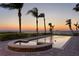 Evening view of a pool reflecting the sunset, with palm trees silhouetted against the horizon at 6106 Marbella Blvd, Apollo Beach, FL 33572